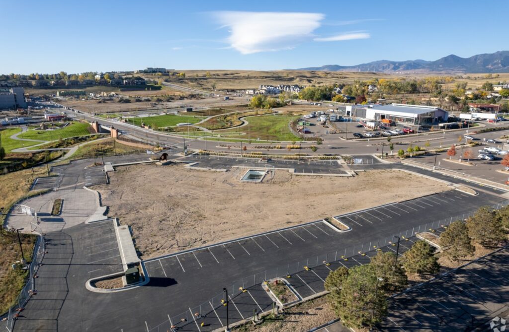 Aerial image of a large dirt area and a parking lot