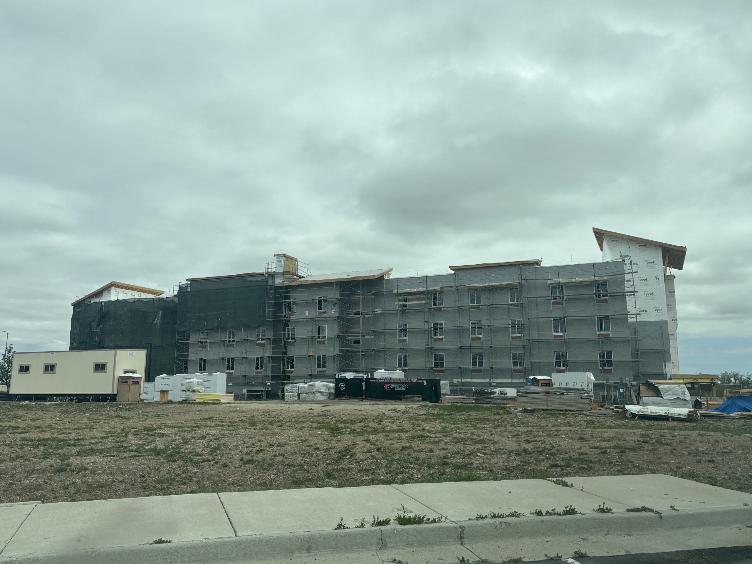 The Hyatt Hotel construction with scaffolding and gray walls going up with construction material in the foreground.